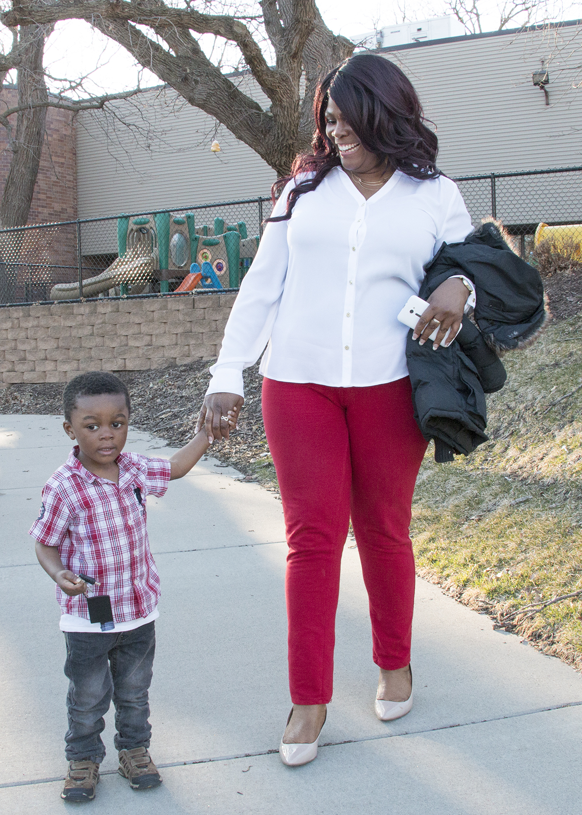 parent and child standing outside preschool, black mother and son at childcare center, child development center family