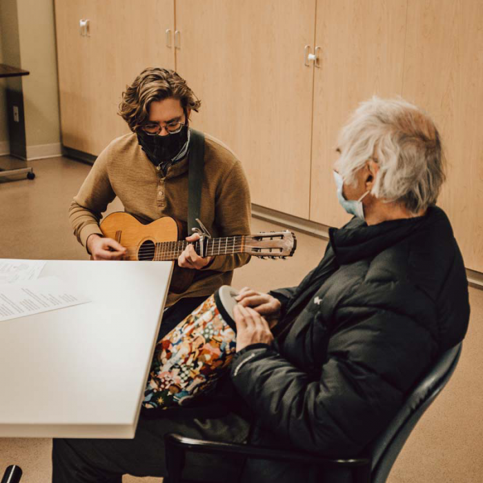 Musician Ryan Evans plays guitar with a participant in Wilder Connect, a respite program at Wilder