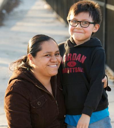 Mother hugging son standing on a pedestrian bridge