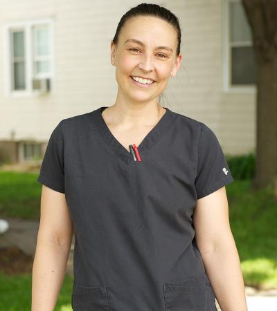 Woman standing in front of a house smiling