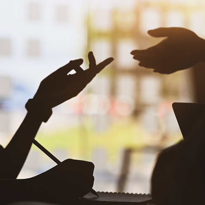 Silhouettes of two people talking.