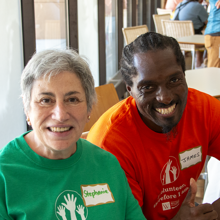 Wilder volunteers Stephanie and James sit at a registration table at a Wilder staff event