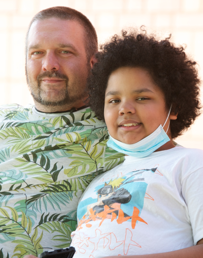 A parent and child sit on a bench.