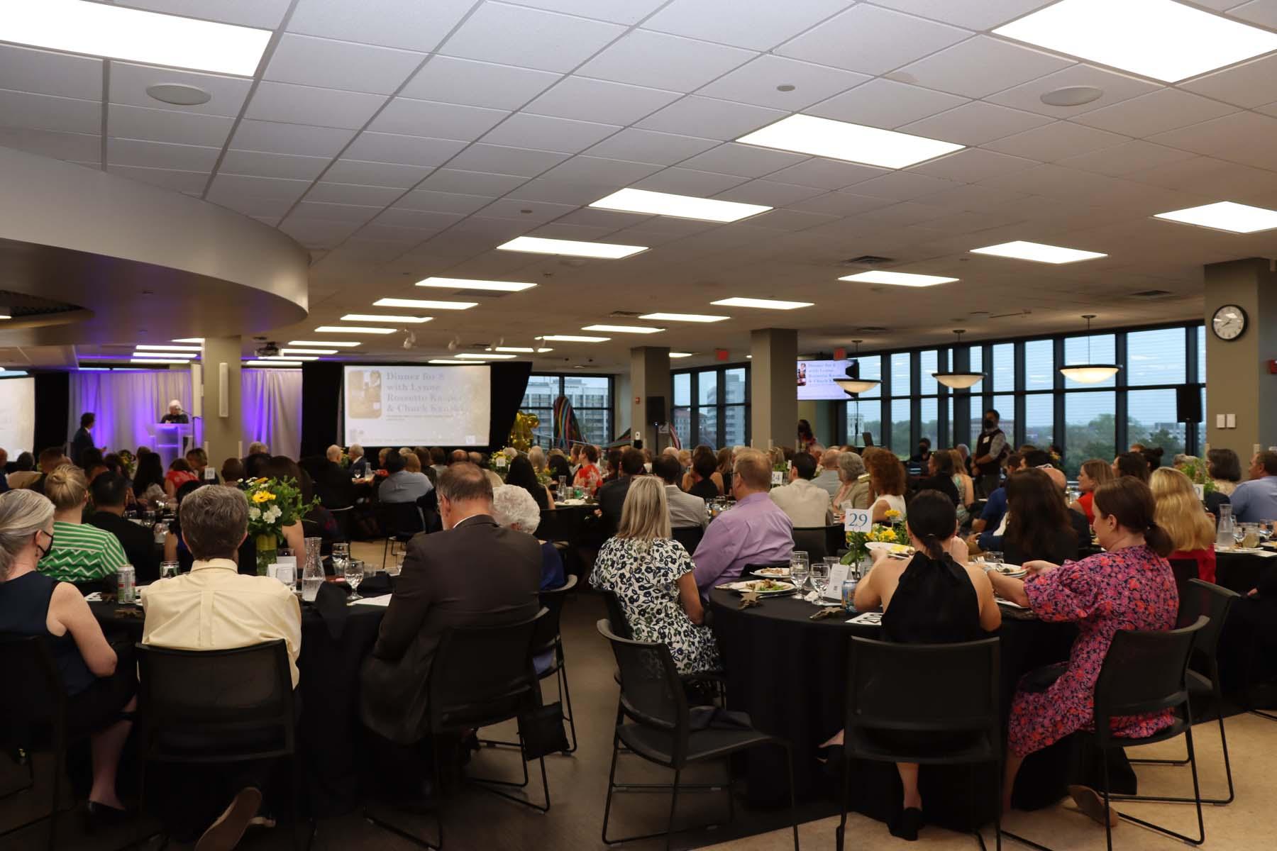 The backs of a large group of people sitting at tables during Ordinary Magic 2022.